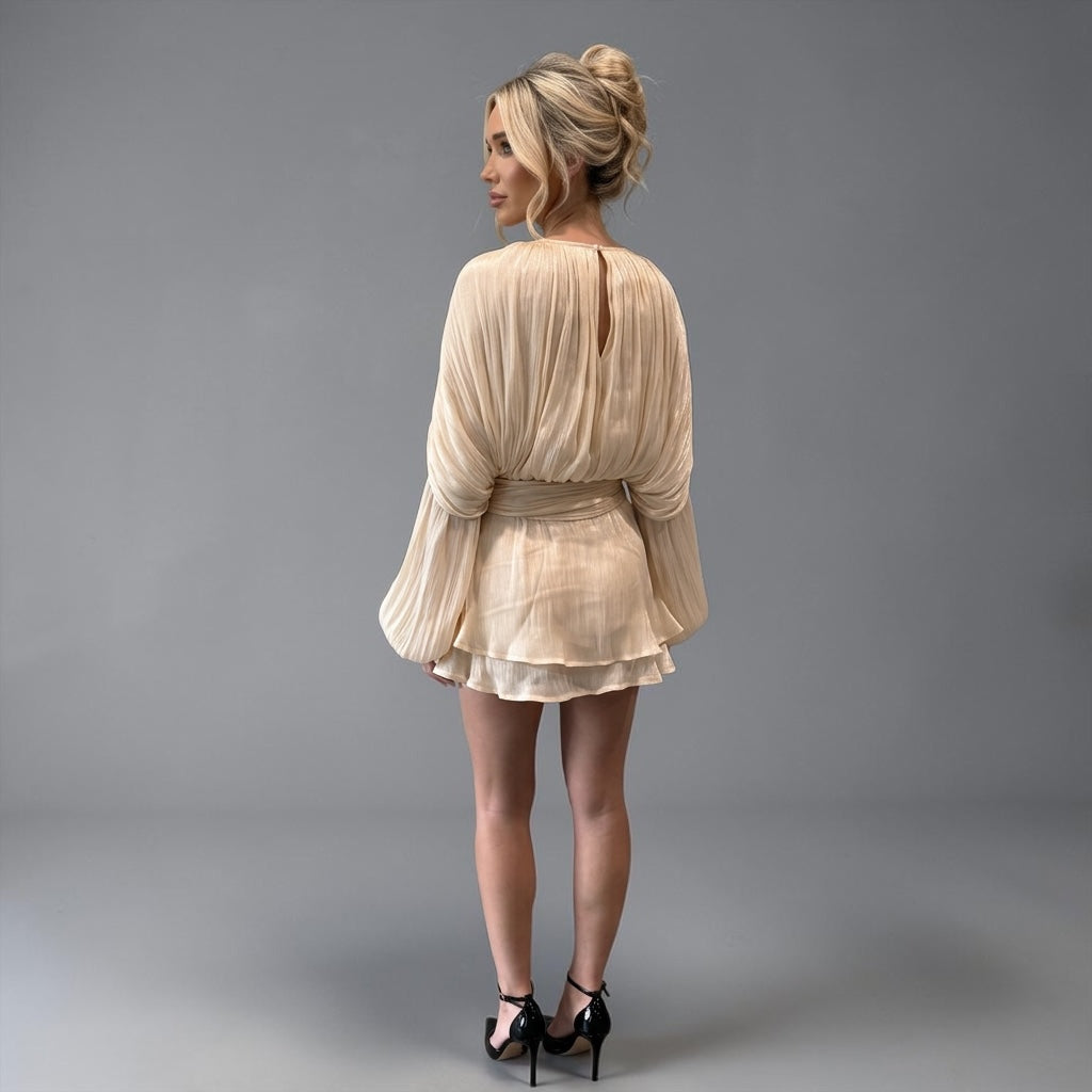 girlzhood Avenique Minikleid in Creme mit langen Volumenaermeln und Drapierung an einer blonden Frau von hinten