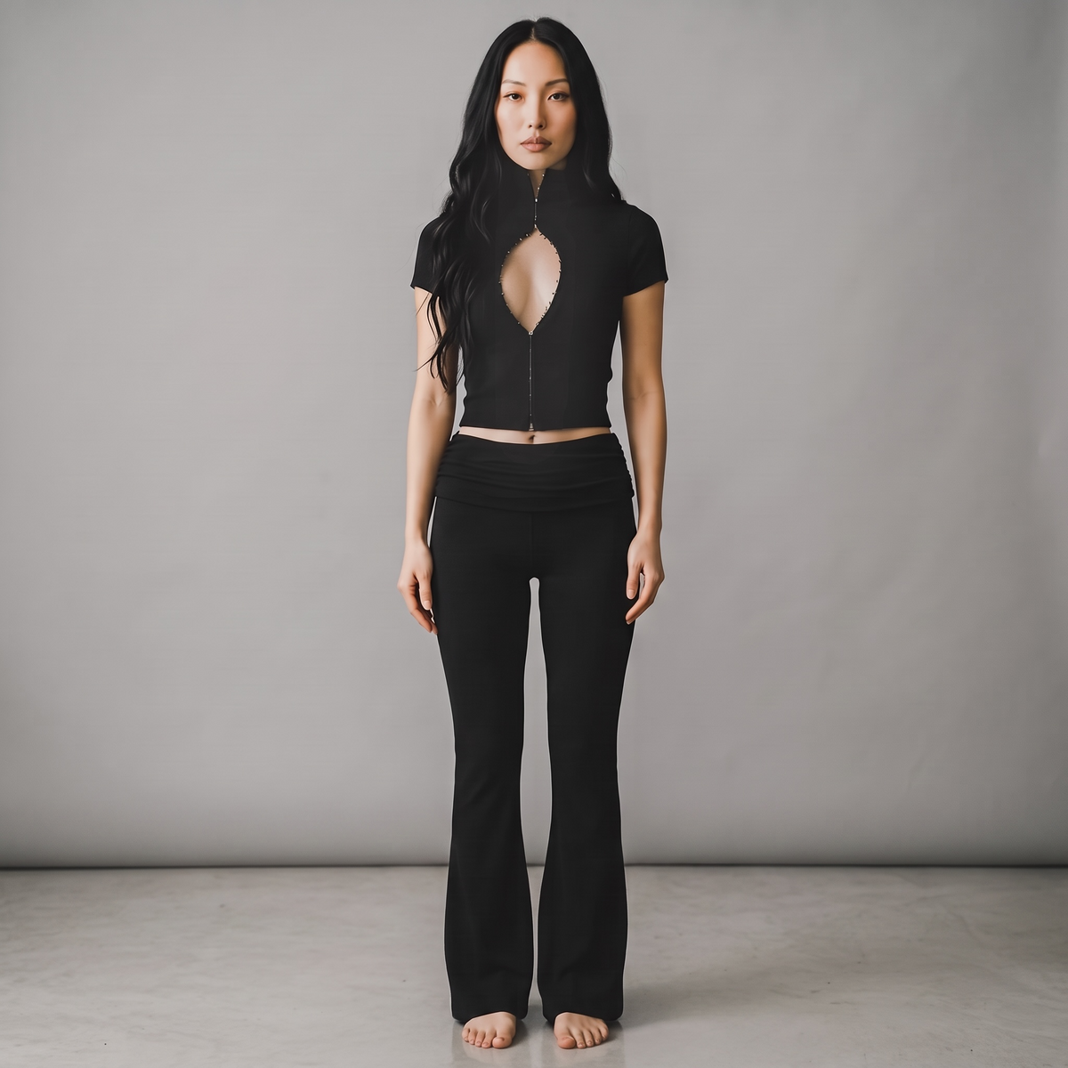 Model trägt girlzhood Bold Touch 2-Teiler in Schwarz mit figurbetontem Oberteil, Cut-Out-Detail und langer Hose