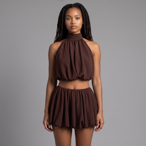 Model trägt girlzhood Brown Amor Set: schokoladenbraunes Neckholder-Top und Ballon-Shorts mit gerafftem Saum.