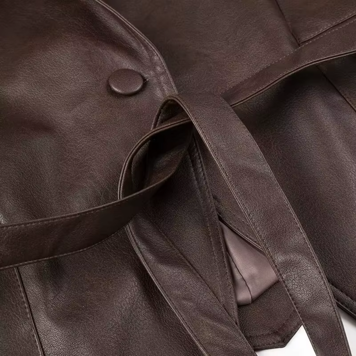girlzhood Celestique Kunstlederjacke in Braun mit Bindegürtel und verdeckter Knopfleiste im Detail