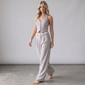 Model trägt das girlzhood Chic Power Suit Set mit ärmellosem Halfter-Top und beiger High-Waist-Hose im Studio