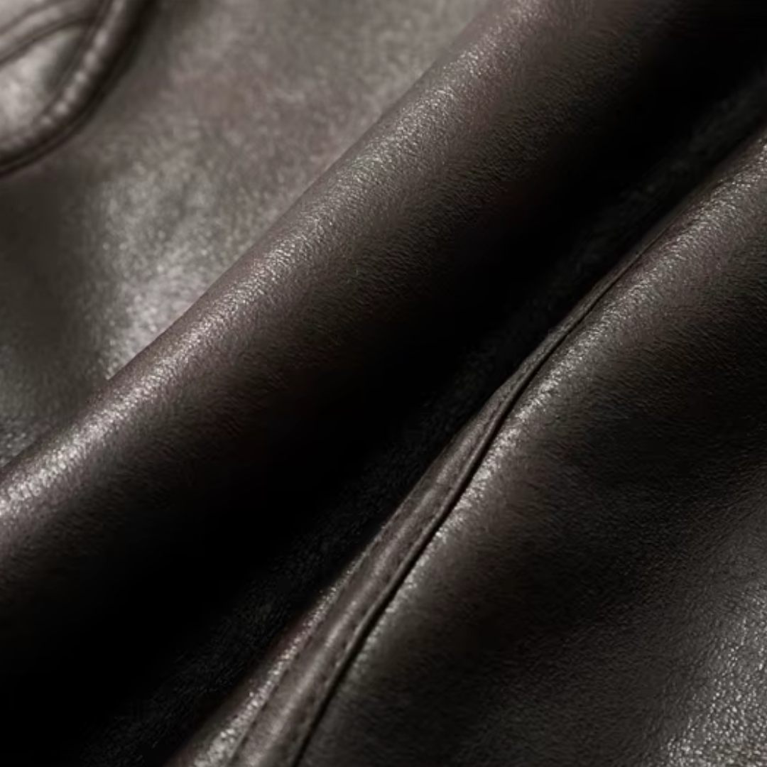 Detailaufnahme der dunklen Kunstleder-Oberfläche der girlzhood Cozy Rebel Jacke mit sichtbaren Nähten