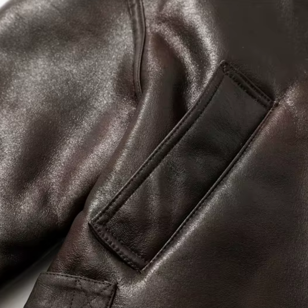 Detailansicht der girlzhood Cozy Rebel Kunstlederjacke in Dunkelbraun mit aufgesetzter Tasche