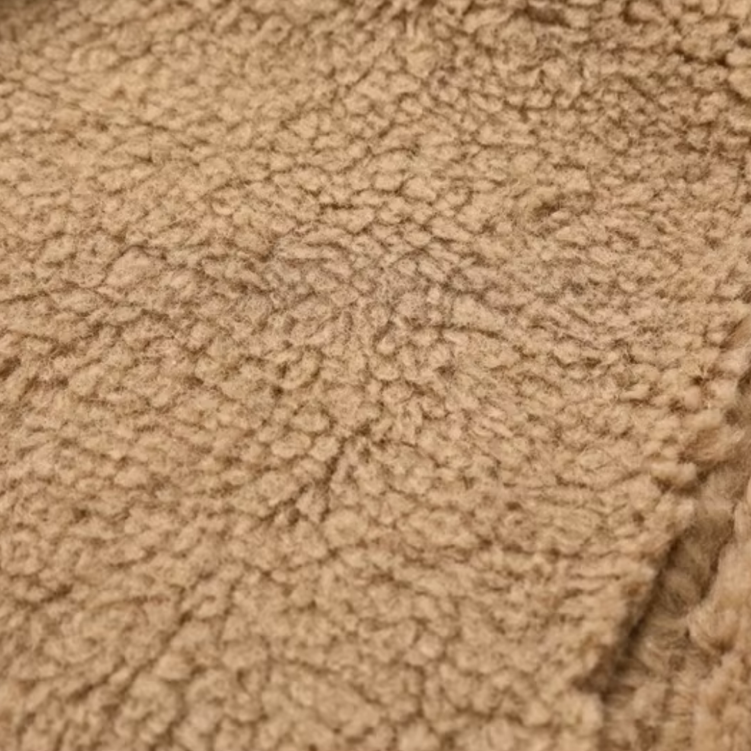 Nahaufnahme des beigen, flauschigen Teddyfutters der girlzhood Cozy Rebel Faux Shearling Jacke