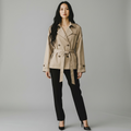 Model trägt girlzhood Empire Luxe kurze beige Trenchjacke mit Taillengürtel, Reverskragen und zweireihiger Knopfleiste