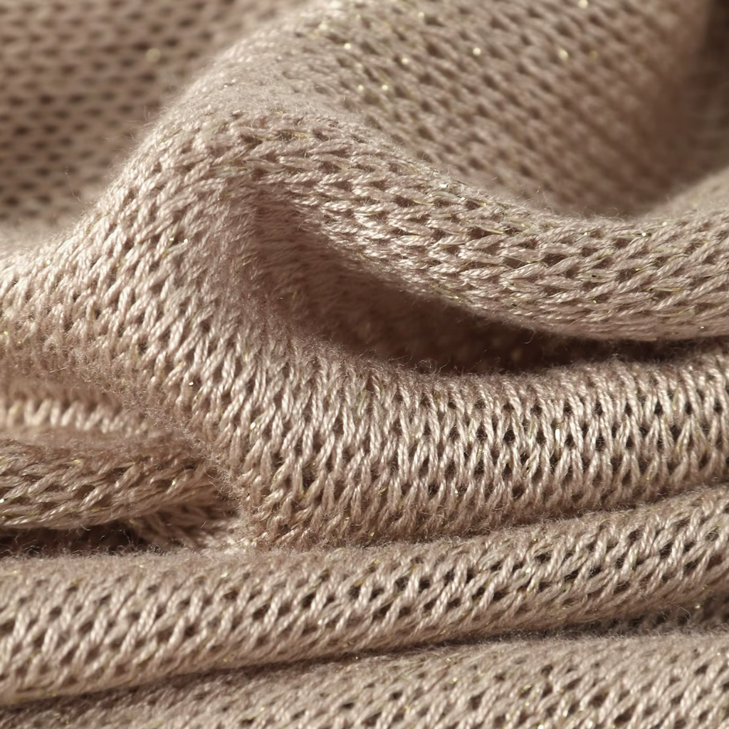 Nahaufnahme des goldenen Strickstoffs vom girlzhood Golden Dune Maxikleid mit feiner Textur und sanftem Glanz.