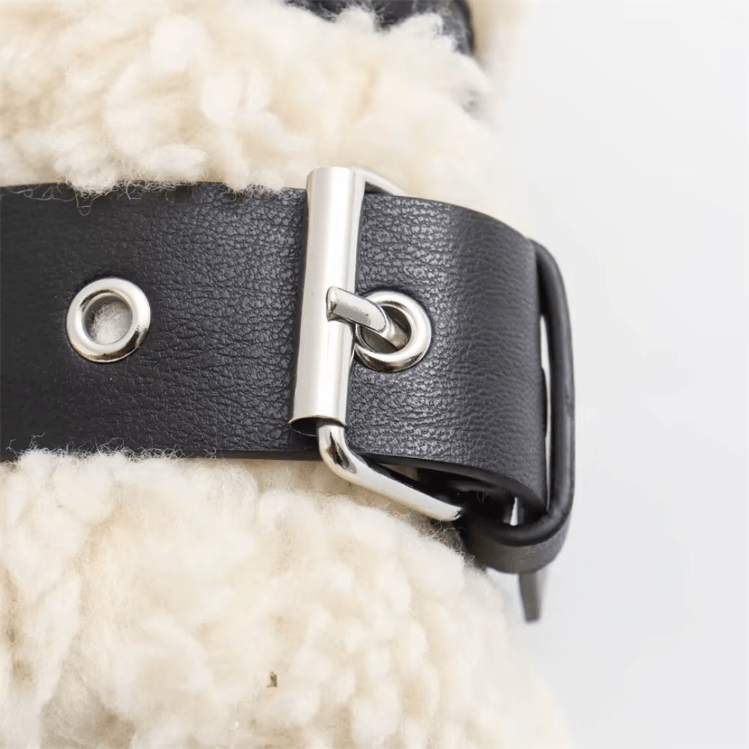 girlzhood Grimelle Mantel aus beigem Teddy-Fell mit schwarzem Leder-Riemen und silberner Schnalle als Detail