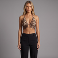 Model trägt ein girlzhood Neckholder-Crop-Top mit Leopardenmuster, Metallring-Detail und Bindebändern am Rücken.