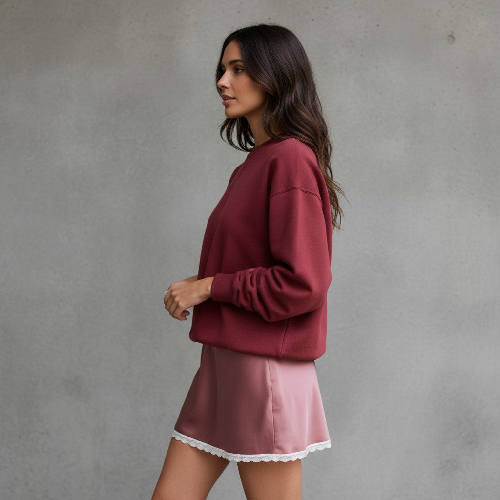 girlzhood Luna Lace Satinrock in Rosa mit weißem Spitzenbesatz kombiniert mit einem weinroten Oversize-Pullover