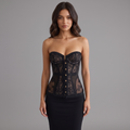 Model trägt girlzhood Midnight Desire Korsett-Top in Schwarz mit transparenter Spitze und goldenen Knöpfen.