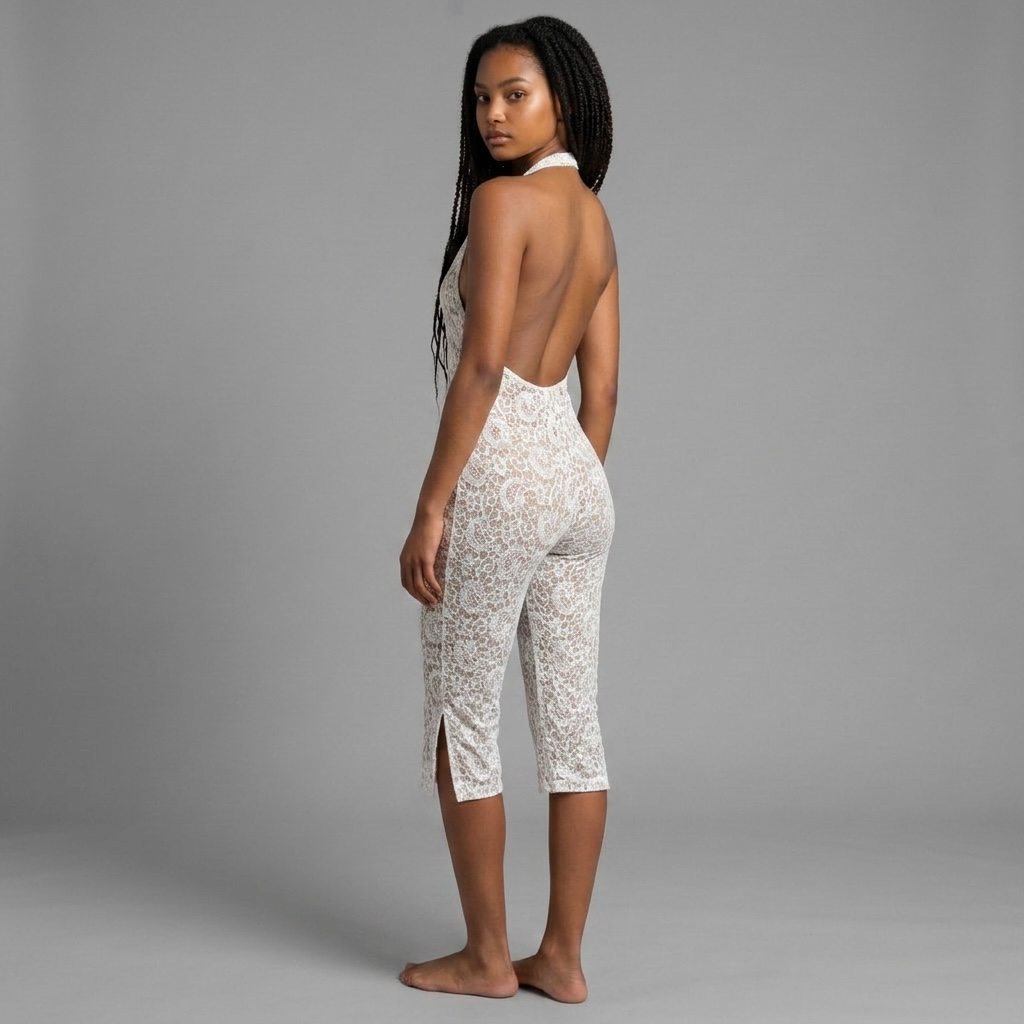Model trägt girlzhood Muse Heat Jumpsuit in Weiß aus luxuriöser Spitze mit Neckholder und offenem Rücken