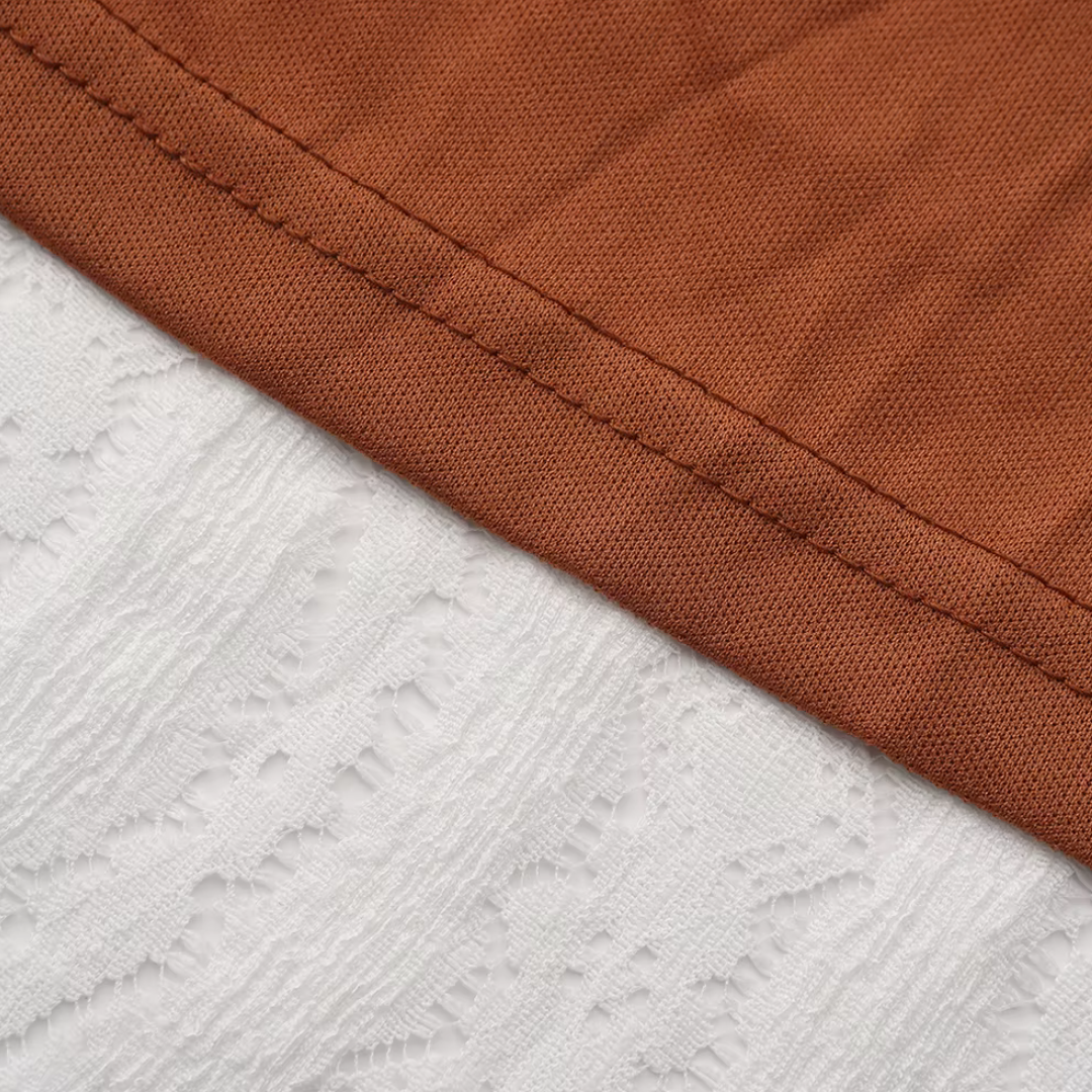 Detailaufnahme des girlzhood Nerissia Kleids mit braunem Stoff und weißem Spitzenbesatz