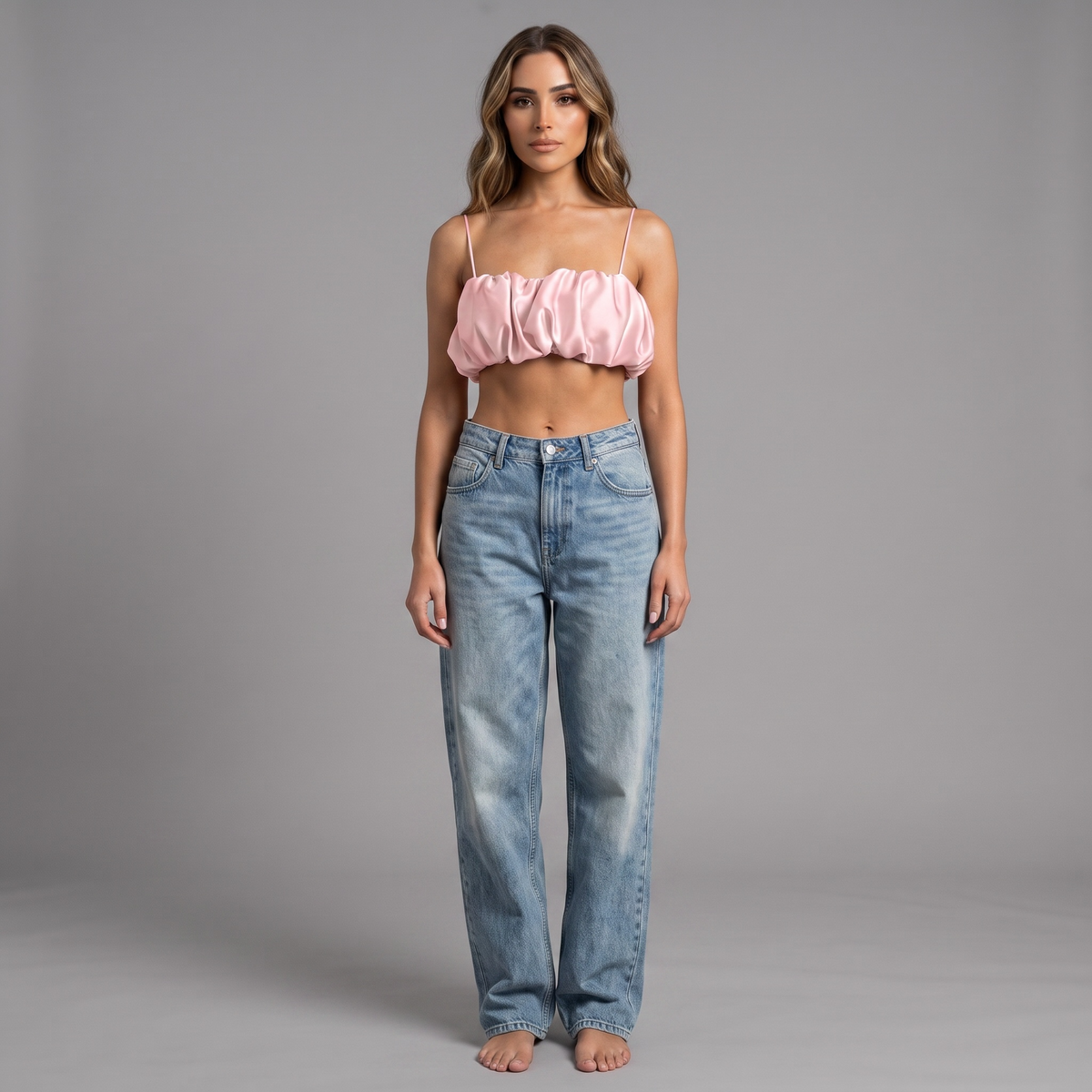 Model trägt girlzhood White Aura Cropped Top in Rosa mit Raffung und feinen Trägern zu einer blauen Jeans