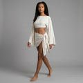 Model trägt das girlzhood Set Thaloria in Beige mit bauchfreiem Oberteil, Fledermausärmeln und Wickelrock.