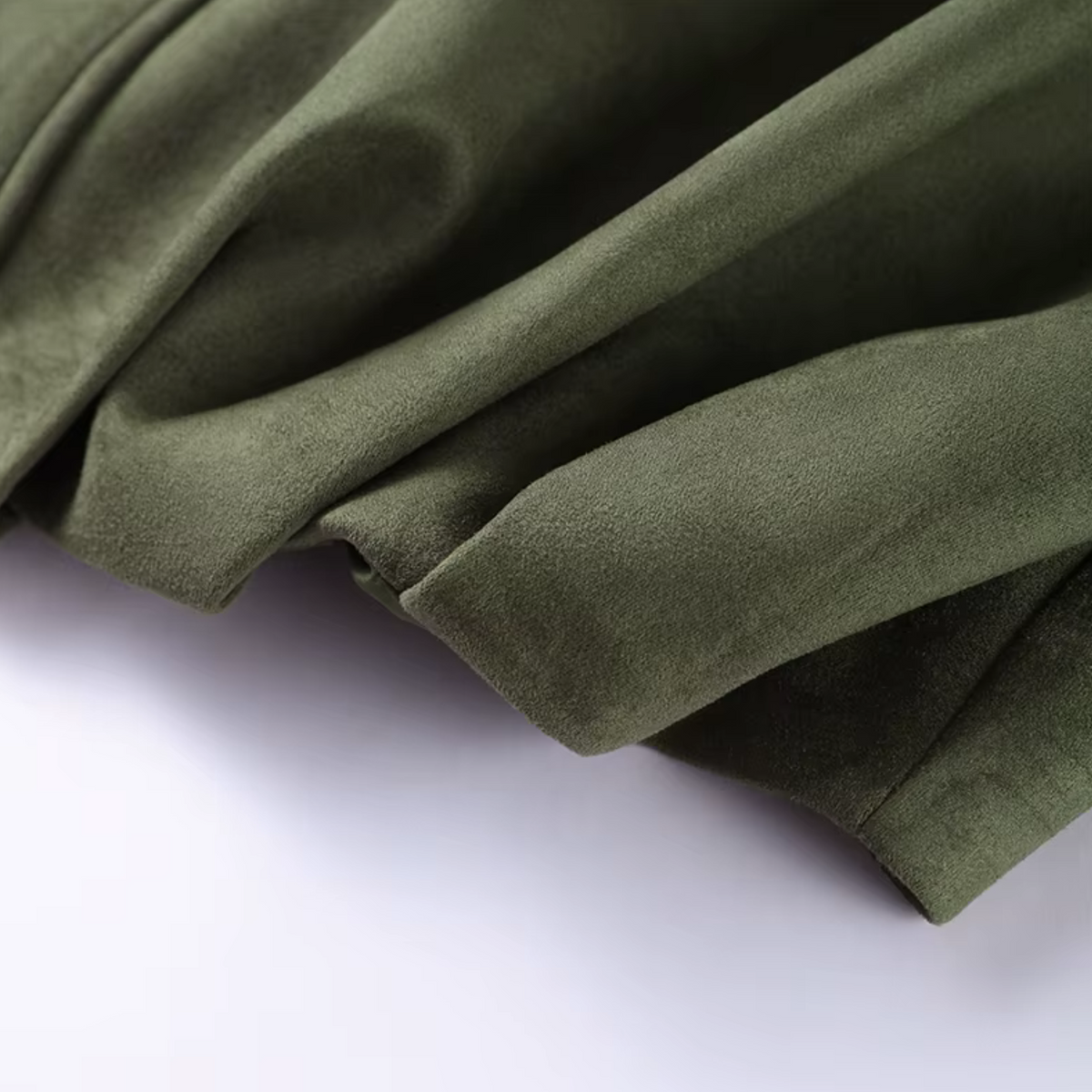 Detailaufnahme des samtweichen, olivgrünen Stoffes der girlzhood Valira Jacke mit strukturierter Oberfläche