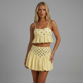 Model trägt das girlzhood Vespera Luxe Set in Soft Lemon mit Rüschentop und ausgestelltem Bubble-Rock mit Gold-Details.