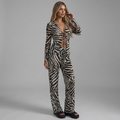 Model trägt girlzhood Savage Muse Zebra Set mit Bindedetails, langärmligem Oberteil und fließender Wide-Leg-Hose.